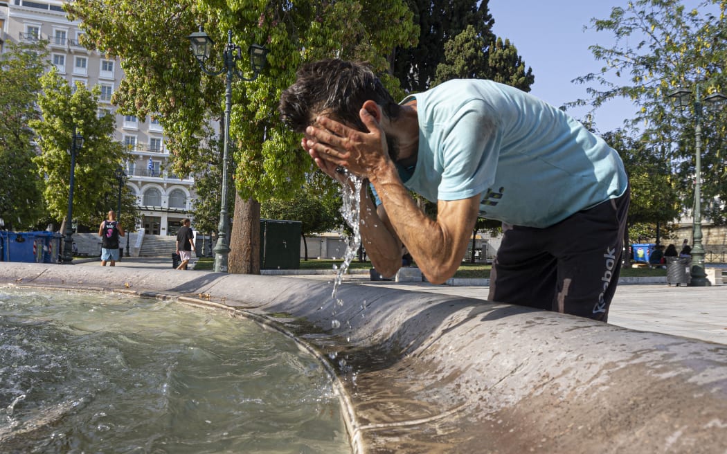 Un homme a également été vu s'éclaboussant le visage avec de l'eau d'une fontaine pour se rafraîchir.  Canicule "  Cléon "  en Grèce.  Scène de la vie quotidienne avec des habitants et des touristes passant devant la célèbre fontaine de la place Syntagma tout en essayant de se rafraîchir avec l'eau de celle-ci et l'ombre sous les arbres alors que les températures dépassent les 40°C.  Athènes, Grèce, le 15 juillet 2023 (Photo de Nicholas Economou/NurPhoto) (Photo de Nicholas Economou/NurPhoto/NurPhoto de l'AFP)