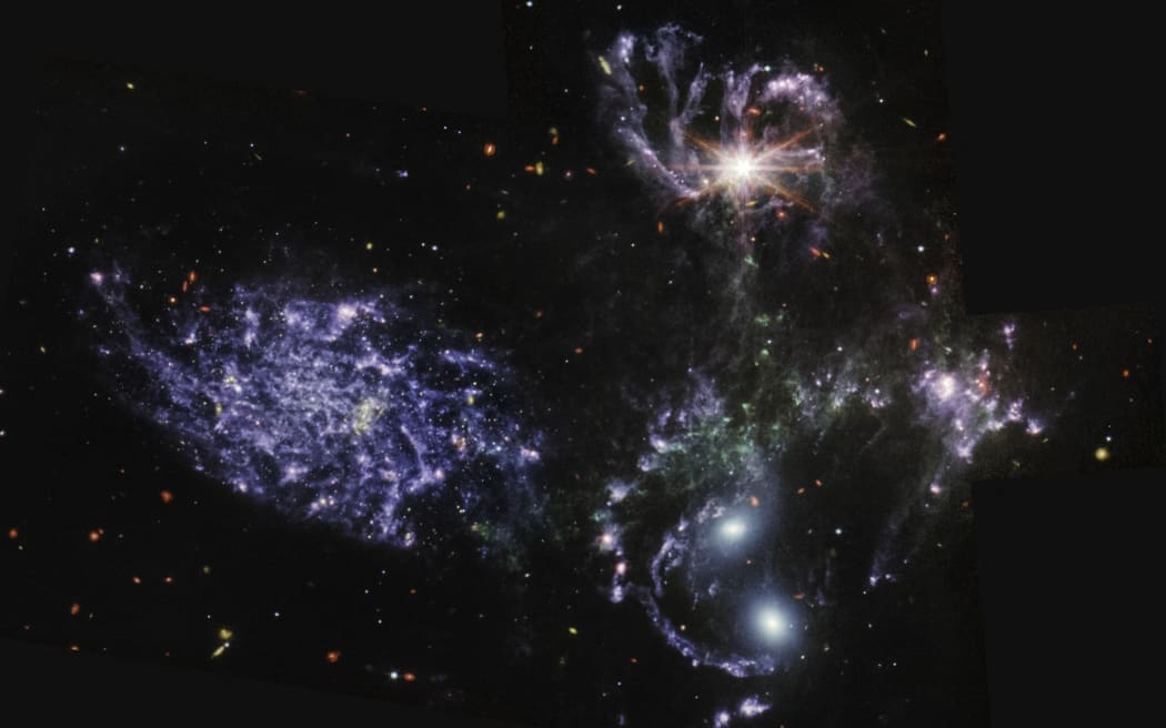 This image released by NASA on July 12, 2022, from the Mid-Infrared Instrument (MIRI) on the James Webb Space Telescope (JWST) shows never-before-seen details of Stephan’s Quintet, a visual grouping of five galaxies. MIRI pierced through dust-enshrouded regions to reveal huge shock waves and tidal tails, gas and stars stripped from the outer regions of the galaxies by interactions. It also unveiled hidden areas of star formation. The new information from MIRI provides invaluable insights into how galactic interactions may have driven galaxy evolution in the early universe. - The JWST is the most powerful telescope launched into space and it reached its final orbit around the sun, approximately 930,000 miles from Earths orbit, in January, 2022. The technological improvements of the JWST and distance from the sun will allow scientists to see much deeper into our universe with greater...