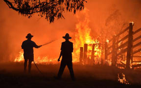 Residents defend a property from a bushfire at Hillsville near Taree, 350km north of Sydney on Tuesday.