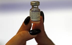 An Israeli health worker displays a vial of the Pfizer-BioNtech COVID-19 vaccine, at the Maccabi Health Service in Jerusalem on August 20, 2021 as Israel launches its campaign to give booster shots to people aged over 40,in a bid to stem spiking infections driven by the Delta variant.
