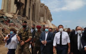 A handout picture provided by the Lebanese photo agency Dalati and Nohra on August 6, 2020, shows French President Emmanuel Macron (2nd-R) and Foreign Minister Jean-Yves Le Drian (R) inspecting the damages at the port of Lebanon's capital Beirut.
