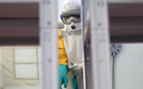 A worker adjusts her gloves as she learns to put on her protective suit during an Ebola training session in Spain.
