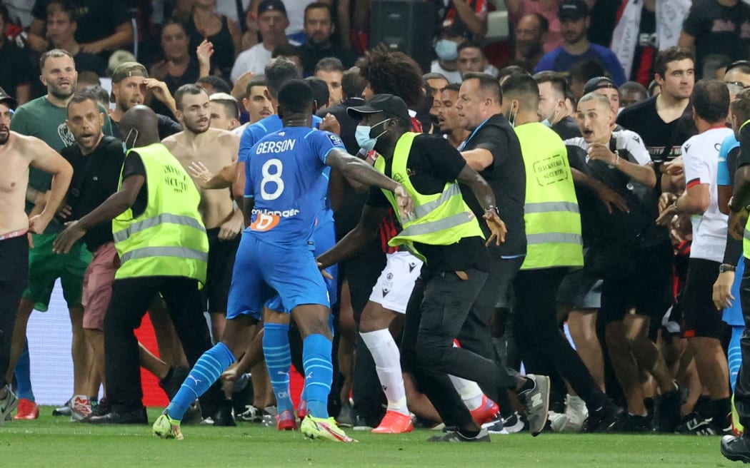 Security try to prevent fans as they invade the pitch during the French L1 football match between OGC Nice and Olympique de Marseille (OM) at the Allianz Riviera stadium in Nice, southern France on August 22, 2021.