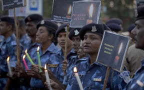 Central Reserve Police Force (CRPF) soldiers hold candles and pay tribute to their colleagues killed in Thursday's attack on a paramilitary convoy in Kashmir, in Hyderabad, India.