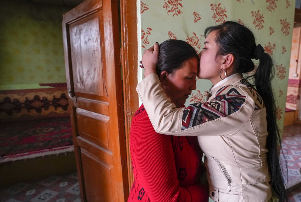 Buzeynep Abulehet,the eldest daughter of a family of six, kisses her mother before leaving for work, at her home in Moyu of Hotan Prefecture, northwest China's Xinjiang Uygur Autonomous Region, March 26, 2020.