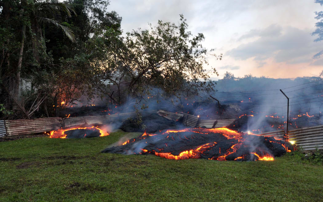 Lava that has pushed through a fence marking a property boundary in Pāhoa village in Hawaii.
