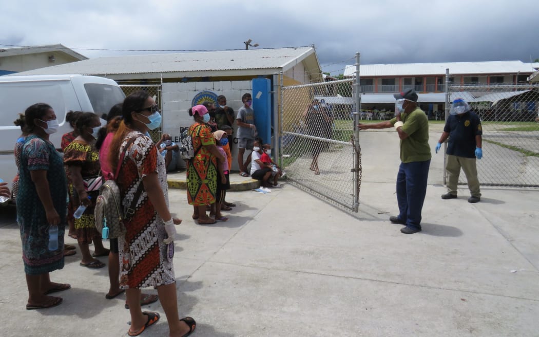 A security officer controls the flow of islanders into one of several community-based alternative care sites established by the Ministry of Health and Human Services to test and treat people in the wake of the Covid outbreak that started August 8.