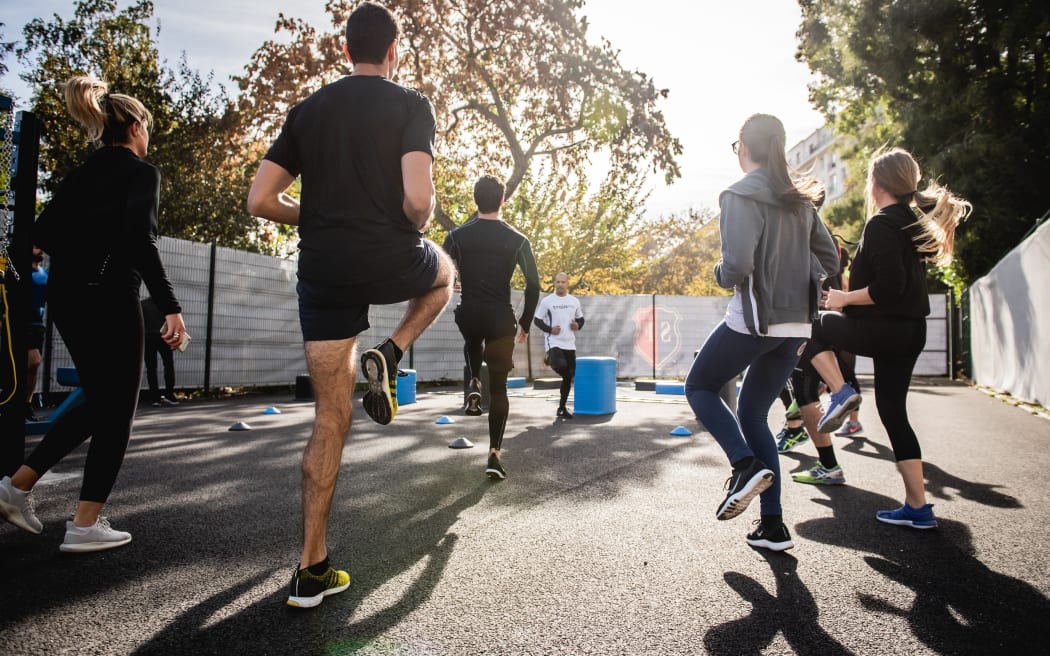 People exercising by running on the spot at an outdoor bootcamp