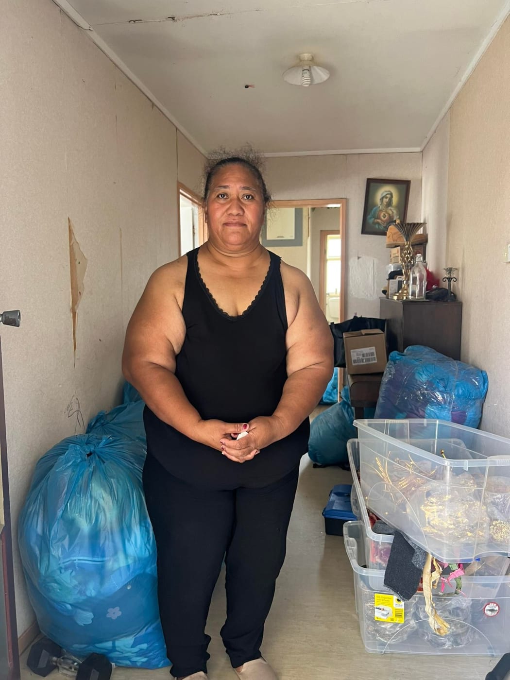 Mangere resident Mesalina at her flood-ravaged home looking for salvageable items