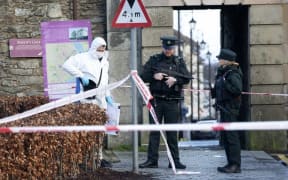 Police Officers and police forensic officers work at the scene in the aftermath of a suspected car bomb explosion in Derry, Northern Ireland, on January 20, 2019.