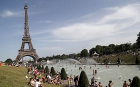 People bathe in the Trocadero Fountain near the Eiffel Tower in Paris during a heatwave on June 28, 2019. )
