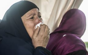 A relative of a passenger who was flying aboard an EgyptAir plane that vanished from radar en route from Paris to Cairo overnight cries as family members are transported by bus to a gathering point at Cairo airport.