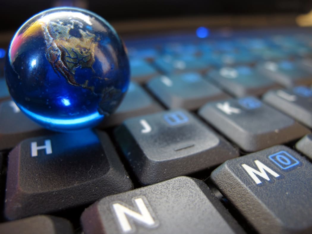 an image of a small glass world globe sitting on a computer keyboard.