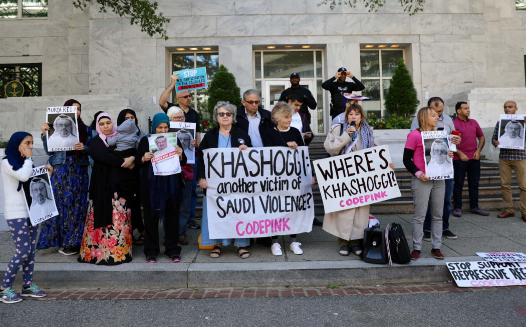 A group of people  hold pictures of missing Saudi journalist Jamal Khashoggi during a demonstration in front of the Embassy of Saudi Arabia in Washington.