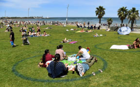 People enjoy the warm weather on Melbourne's St Kilda Beach on November 3, 2020, as Australia's Victoria state records its fourth straight day of zero transmissions of the COVID-19 coronavirus
