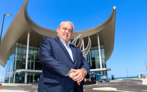Papua New Guinea APEC minister Justin Tkatchenko standing infront of APEC House in Port Moresby.