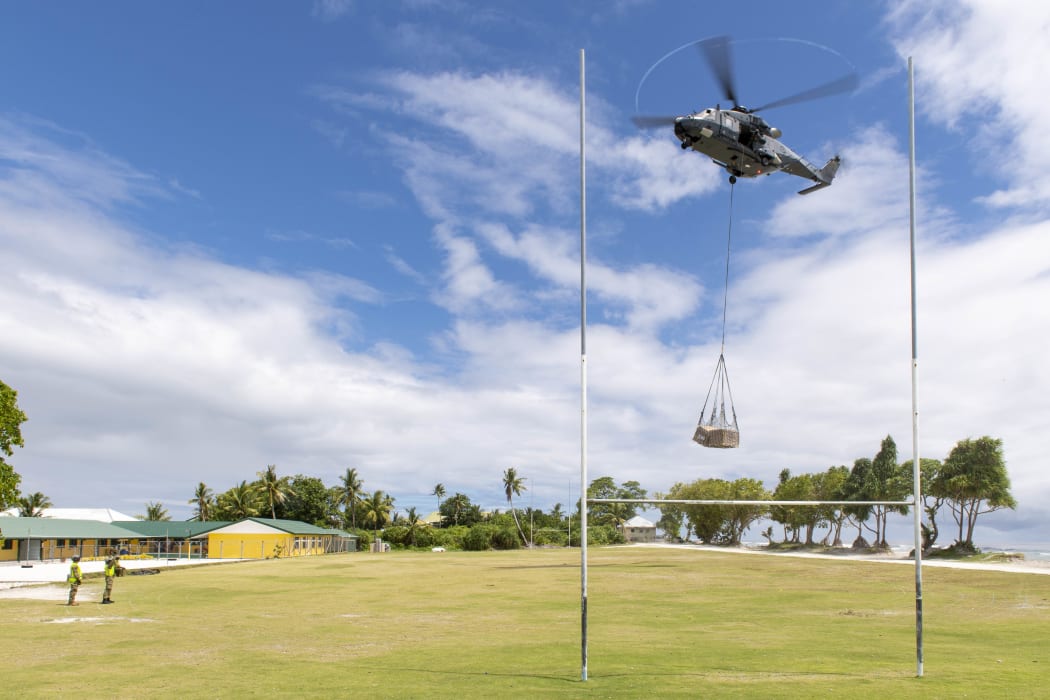Air crew on a RNZAF NH90 helicopter deliver an underslung load of equipment. A specialist team from NZ Army’s 5 Movements Company offloaded equipment in landing zones on the atolls.