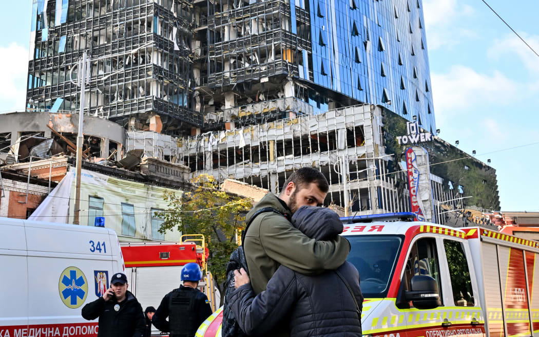 People outside outside a partially destroyed multi-storey office building after Russian strikes hit the Ukrainian capital of Kyiv on 10 October, 2022.