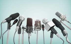 Various microphones aligned at press conference.