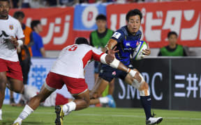 Japan's Kenki Fukuoka runs past David Halaifonua of Tonga to score