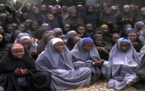 A screengrab from the Boko Haram video of shows girls, wearing the full-length hijab and praying in a rural location.