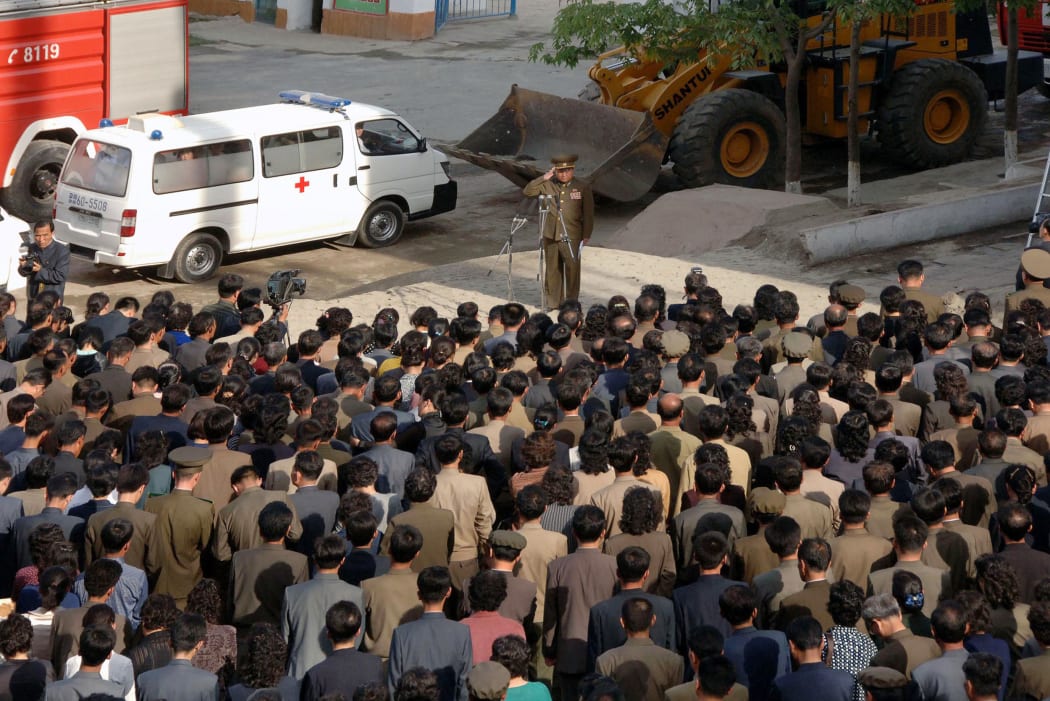 A picture released by KCNA showing a construction division officer (top) apologising to residents following the accident.