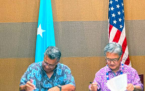 FSM Chief Negotiator Leo A. Falcam, Jr., left, joins with Special Presidential Envoy Joseph Yun on Monday this week in Pohnpei to initial a nearly final version of the new 20-year funding agreement for extending the Compact of Free Association.