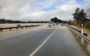 A car drives through flooding in Northland on 18 July.