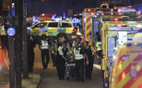 Police and members of the emergency services attend to a person injured in the London Bridge attack.