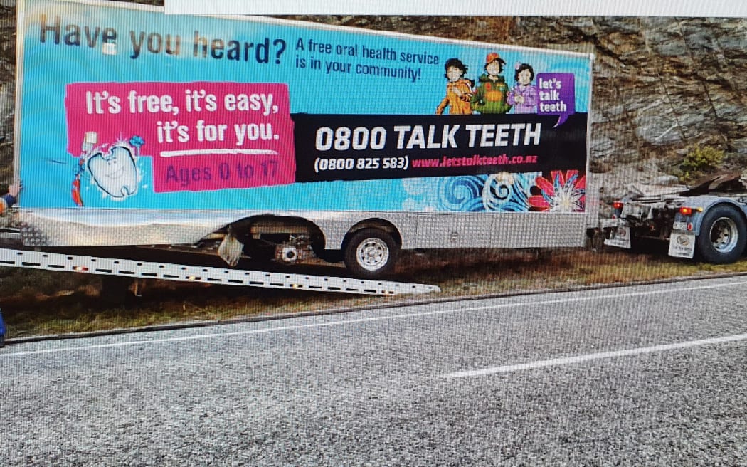 The mobile dental clinic, minus a wheel, is loaded on to the back of a truck near Cromwell.
