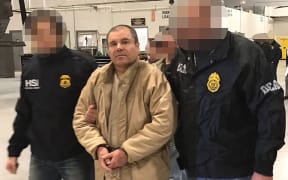 This handout picture released by the Mexican Interior Ministry on January 19, 2017 shows Joaquin Guzman Loera aka "El Chapo" Guzman escorted in Ciudad Juarez by the Mexican police.
