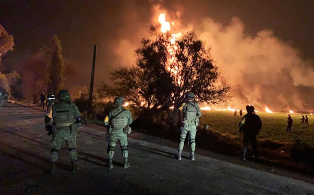 Mexican soldiers standing guard near a fire after a leaking gas pipeline triggered a blaze in Tlahuelilpan, Hidalgo state, on January 18, 2019.