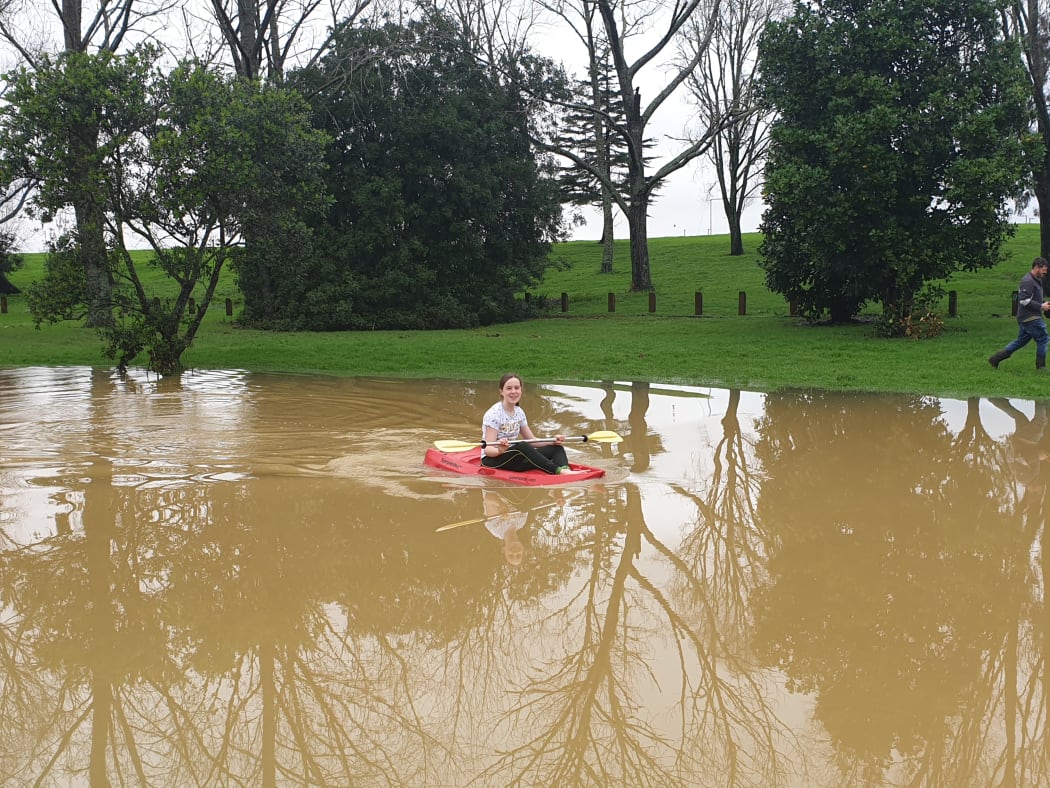 A girl kayaking in floodwaters in Whangārei.