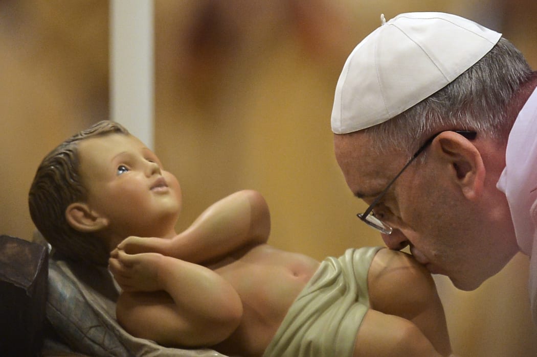 Pope Francis kisses the unveiled baby Jesus at St Peter's.