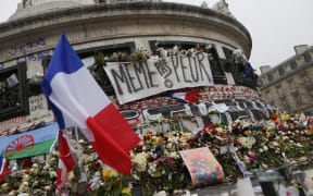 A picture taken on November 27, 2015, shows French national flags, candles and flowers at a makeshift memorial in Place de la Republique square in Paris.