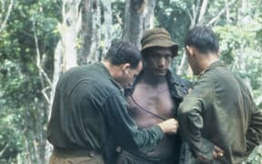 An Australian medical officer treating the New Zealand W Company during a resupply in the field during the Vietnam War.
