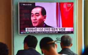 People watching a news broadcast showing file footage of Thae Yong-ho at a railway station in Seoul.