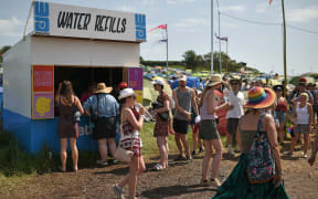 Revellers queue to fill their water bottles at a water re-filling station at the Glastonbury Festival.