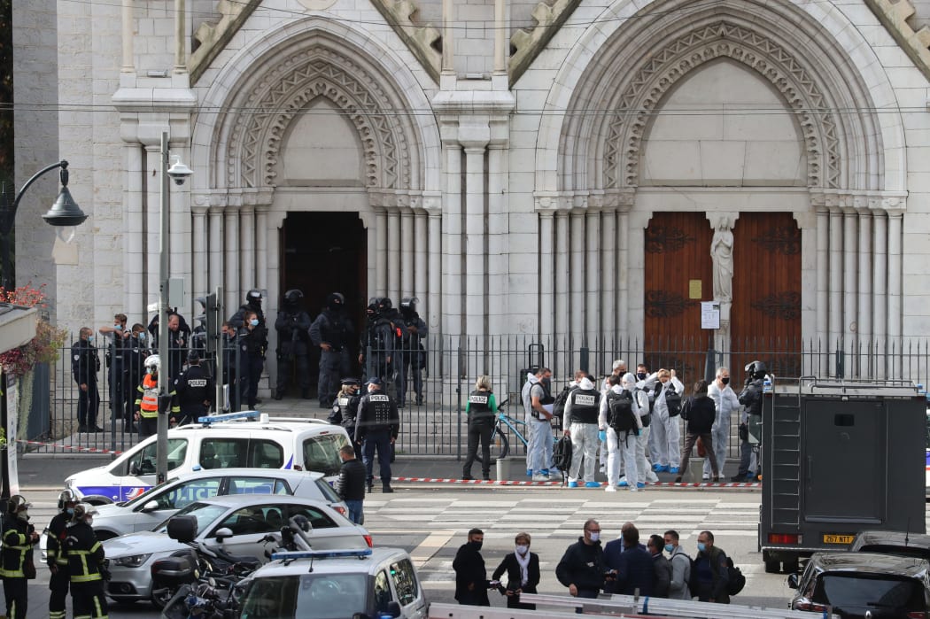 French members of the elite tactical police unit RAID enter to search the Basilica of Notre-Dame de Nice as forensics officers wait after a knife attack in Nice on October 29, 2020.