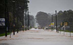 This picture shows a main road of a residential area flooded during heavy rain in western Sydney on March 20, 2021, amid mass evacuations being ordered in low-lying areas along Australia's east coast