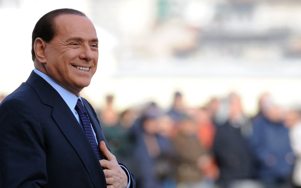 In this file photo taken on November 18, 2008 Italian Prime Minister Silvio Berlusconi arrives to greet German Chancellor Angela Merkel at Piazza Unita d'Italia prior an Italy and Germany summit in Trieste, on the northern Adriactic coast of Italy.