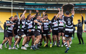 Hawke's Bay players celebrate lifting the Ranfurly Shield off Wellington.