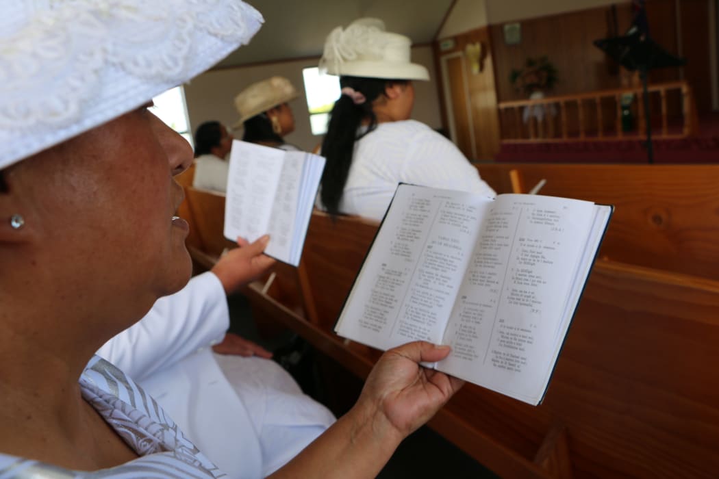 A lady singing from a hymnal at the Samoan Methodist Church in Levin.