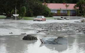 The Waiho River bursts its banks and runs through the Mueller Hotel in Franz Joseph