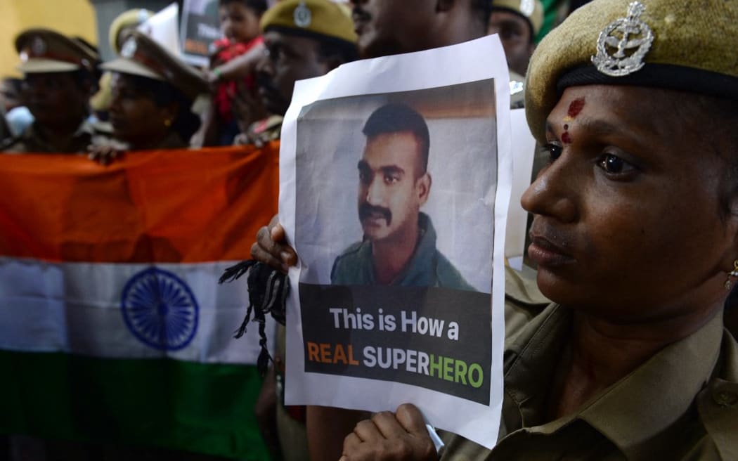 Indian security forces pose with the national flag and pictures of Indian Air Force pilot Abhinandan Varthaman during an event to pray for his return, at Kalikambal temple in Chennai on March 1, 2019. - Thousands of Indians, some waving flags and singing, gathered March 1 to give a hero's welcome to an air force pilot due to be returned across the border after being shot down by Pakistan. (Photo by ARUN SANKAR / AFP)