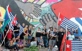 June Mills surrounded by supporters in front of her mural that was later painted over.