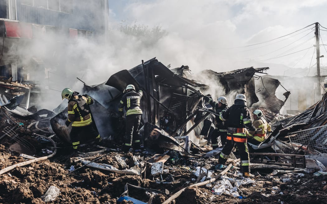 Des pompiers ukrainiens travaillent sur le marché de Bakhmut après qu'il a été bombardé par l'armée russe, dans la ville de Bakhmut, dans l'oblast de Donetsk en Ukraine, le 21 juillet 2022.