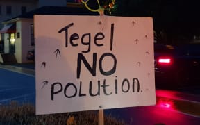 A sign reading 'no pollution' held by a protester at outside a hui held by Tegel in Auckland on Wednesday 6 June 2018.