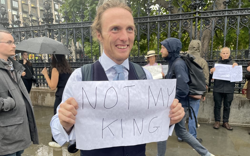 Anti-monarchist protester, Paul, holds a sign reading 'Not My King' in London.