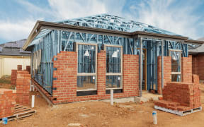 New residential construction home from brick with metal framing against a blue sky